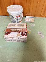 Overall lot showing tile box, adhesive pail and trowel