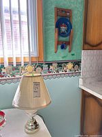 Lamp on table showing metal base, ceramic accent and shade