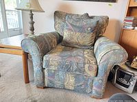 Front three-quarter view of armchair showing overall design, rolled arms, cushions and feet