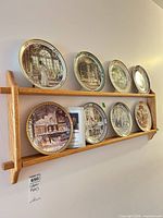 Overall view of seven plates on oak rack mounted on wall