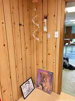 Overall view showing wind chime, ceramic poodle, framed kitten print, framed caricature drawing