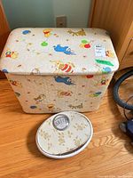 Front view of quilted vinyl children’s chest and bathroom scale on floor