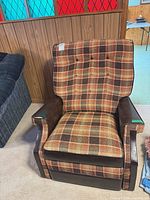 Front view showing plaid upholstery and vinyl arms
