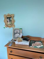 Overall lot on dresser showing framed Jesus print, crucifix, books, Bible