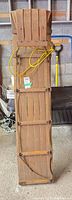 Full view of wooden sled front showing slatted deck and rope