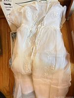 Front view of embroidered organza christening gown in box