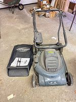 Full view of mower with grass bag and manual