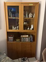 Full view of teak corner cabinet with glass doors and lower storage