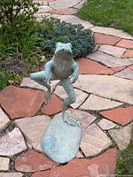 Front view of verdigris frog fountain sculpture on stone-look base
