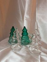 front view of four glass Christmas tree containers