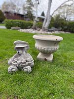 Teddy bear sailor statue and urn planter on lawn