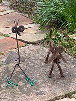 Front view of bird and dog sculptures on stone surface
