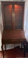 Full view of combined secretary desk and hutch with doors closed, lights on