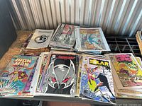 Stacked comic books showing Iron Man, ShadowHawk, Solar, The Spectacular Spider-Man