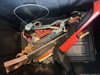 Overview of tote showing axe, cable puller, carpenter square and assorted tools