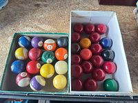 Two boxes containing assorted pool and snooker balls
