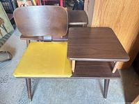 Full view of wooden telephone bench showing yellow vinyl seat and two-tier side table