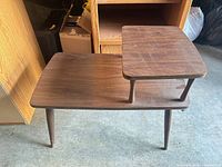 Full view of two-tier wooden side table, showing both surfaces and legs
