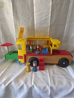 Side view of camper with patio extended and three figures positioned in front