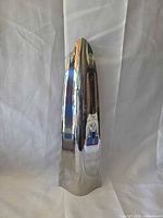 Front view of polished stainless steel Georg Jensen vase
