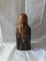 Front view of carved wood bearded man figure