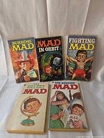 Front covers of all five MAD paperbacks