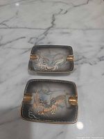 Top view showing both ashtrays with dragon motif and gold rests