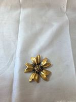 Front view of gold-tone flower brooch