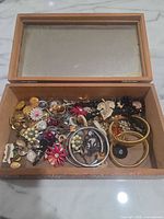 Entire open wood box showing mixed jewellery and buttons