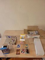 Overall lot on tabletop: sealed box, long white storage box, USPS box, loose displayed cards