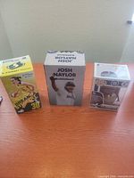 Front view of three boxed bobbleheads