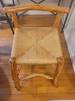Front top view of the stool showing woven seagrass seat and solid wood frame