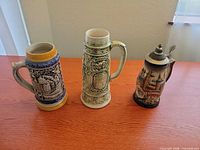 Front view of all three German beer steins on table