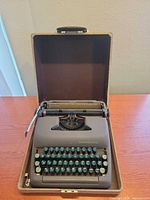 Typewriter seated in open carrying case