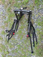Full view of folded rack showing frame, arms and straps