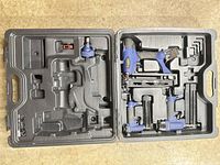 Open case showing three blue pneumatic tools, accessories and molded compartments