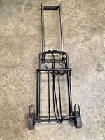 Front view of folded metal hand truck showing frame, handle and wheels