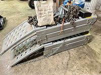 Folded pair of steel ramps with chains, springs and paper bag of adjusters