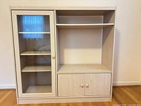 Front view of full cabinet showing glass door, open shelving and lower doors