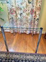 Front view of square glass top table with chrome legs