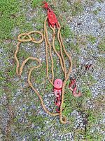 Entire block and tackle assembly with rope and chain laid out on gravel