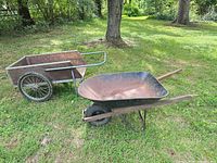 wheelbarrow and garden cart side by side on lawn