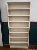 Front view of entire white wood CD shelf showing eight shelves