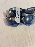 Three stacked pairs showing blue lenses and black frames