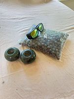 Bag of marbles, sunglasses, two green stone candle holders
