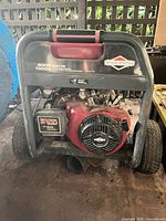 Front view of Briggs & Stratton generator showing engine, frame, wheels, model wattage labels