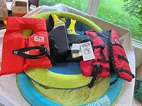 Overview showing three life jackets on top of SwimWays Spring Float