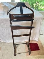 Front view of valet stand showing hanger, bars and casters