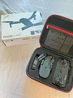 Carry case opened showing folded drone, battery, remote controller