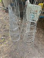 Multiple stacks of wire tomato cages on ground